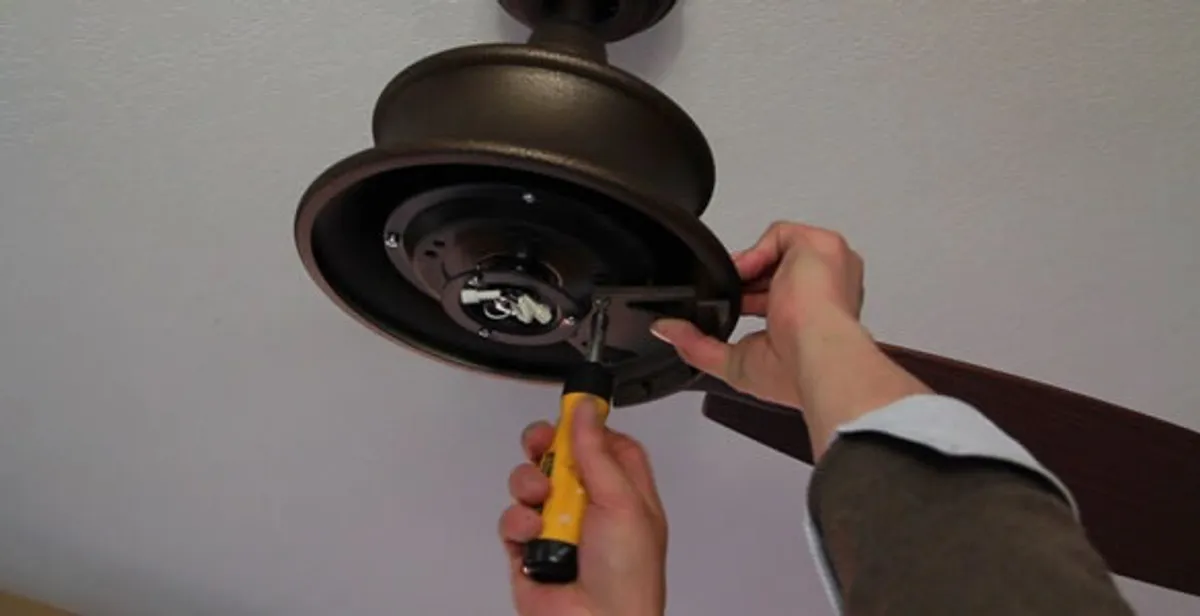 Electrician installing ceiling fan mounting bracket and fixture in Tacoma, WA