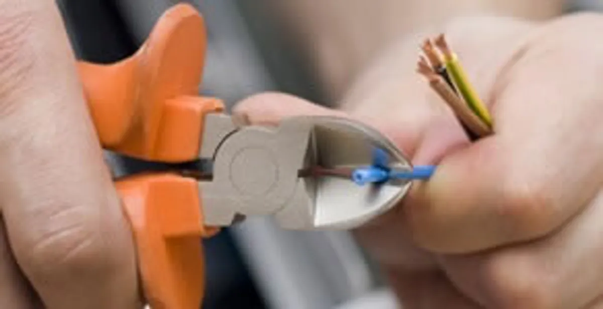 licensed electrician performing precise wire cutting and preparation during electrical service in Tacoma, WA