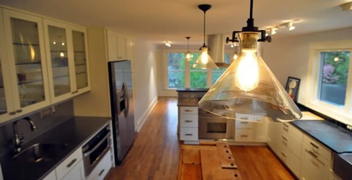 Residential electrician installing modern indoor light fixture in a home in Tacoma, WA